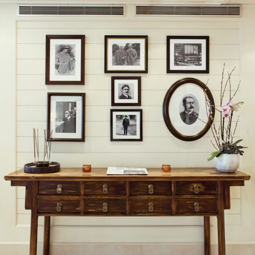 Hotel Kipling, frames with portraits on a wooden desk. - Gitaly contract